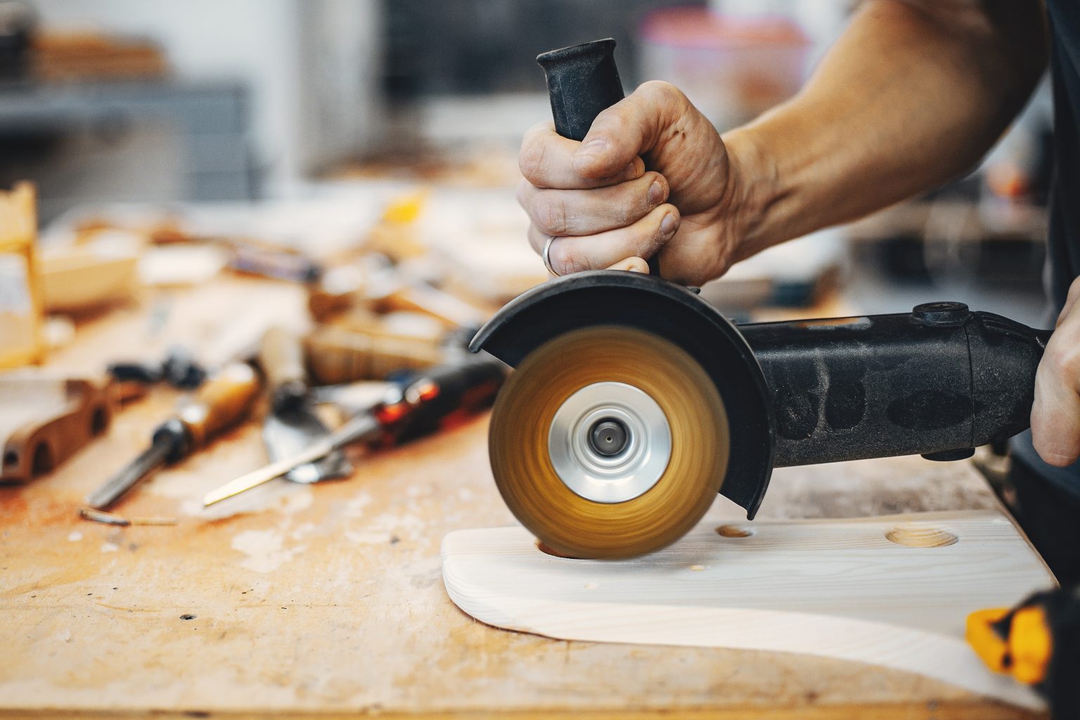 A man carves a tree. The carpenter works in a studio. An engineer provides a tree shape
